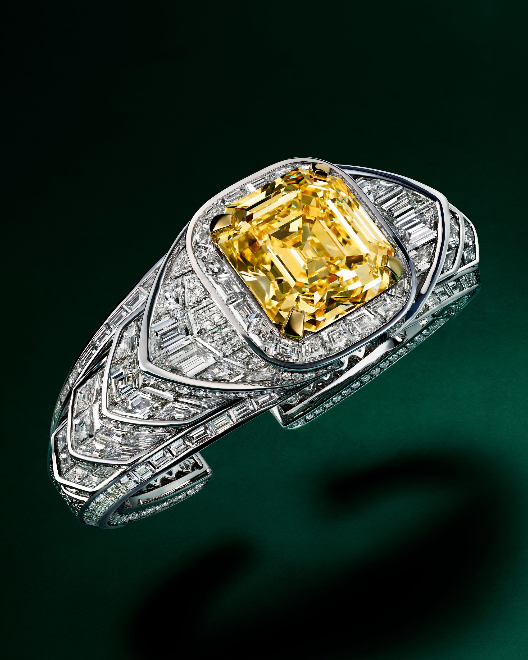 A Graff cuff features graphic lines of white diamonds centered on a 40-carat emerald-cut yellow diamond.