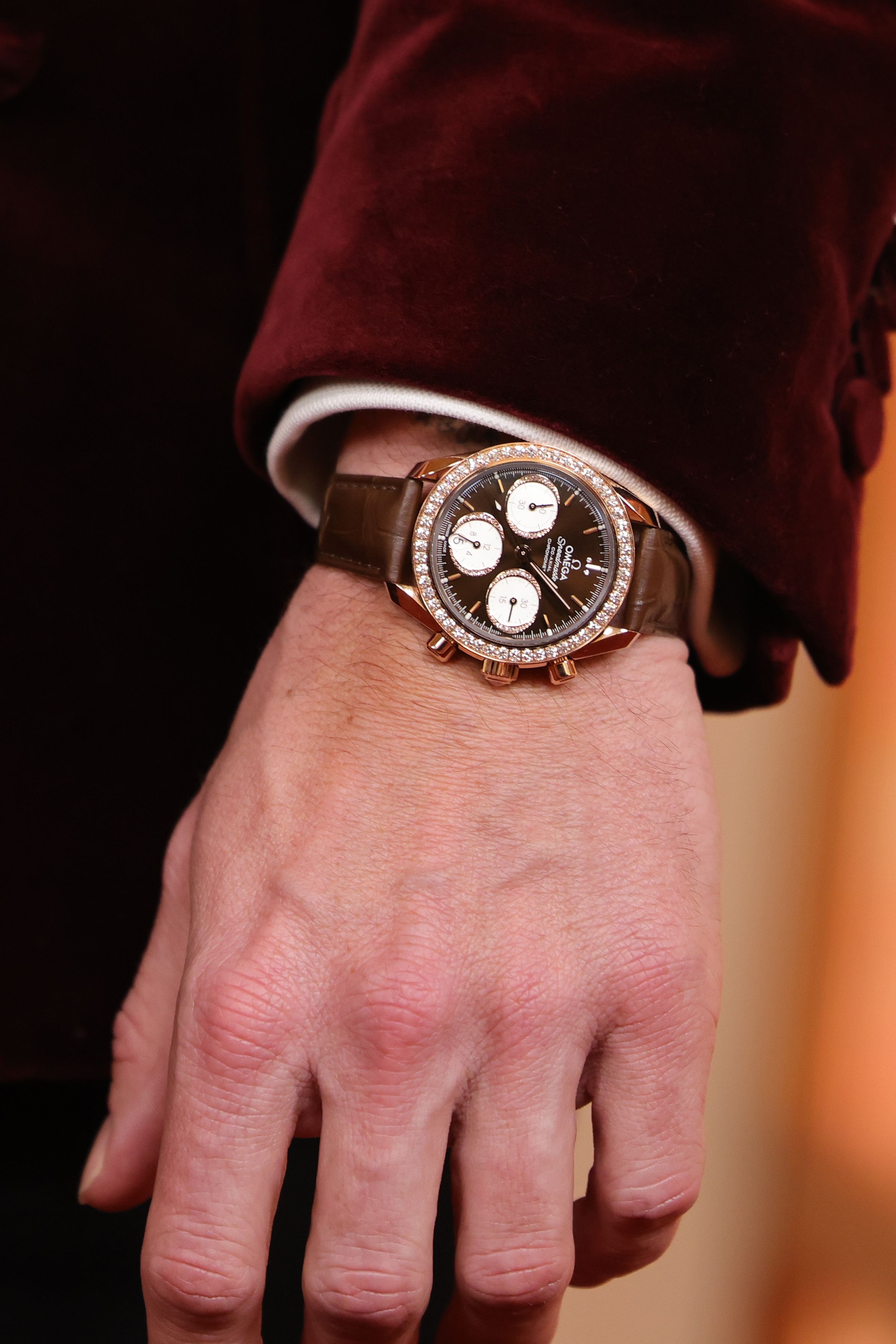 Attendee Chase Stokes wore an Omega 38 mm Speedmaster in 18K Sedna&trade; Gold featuring a diamond-set bezel on a brown leather strap.