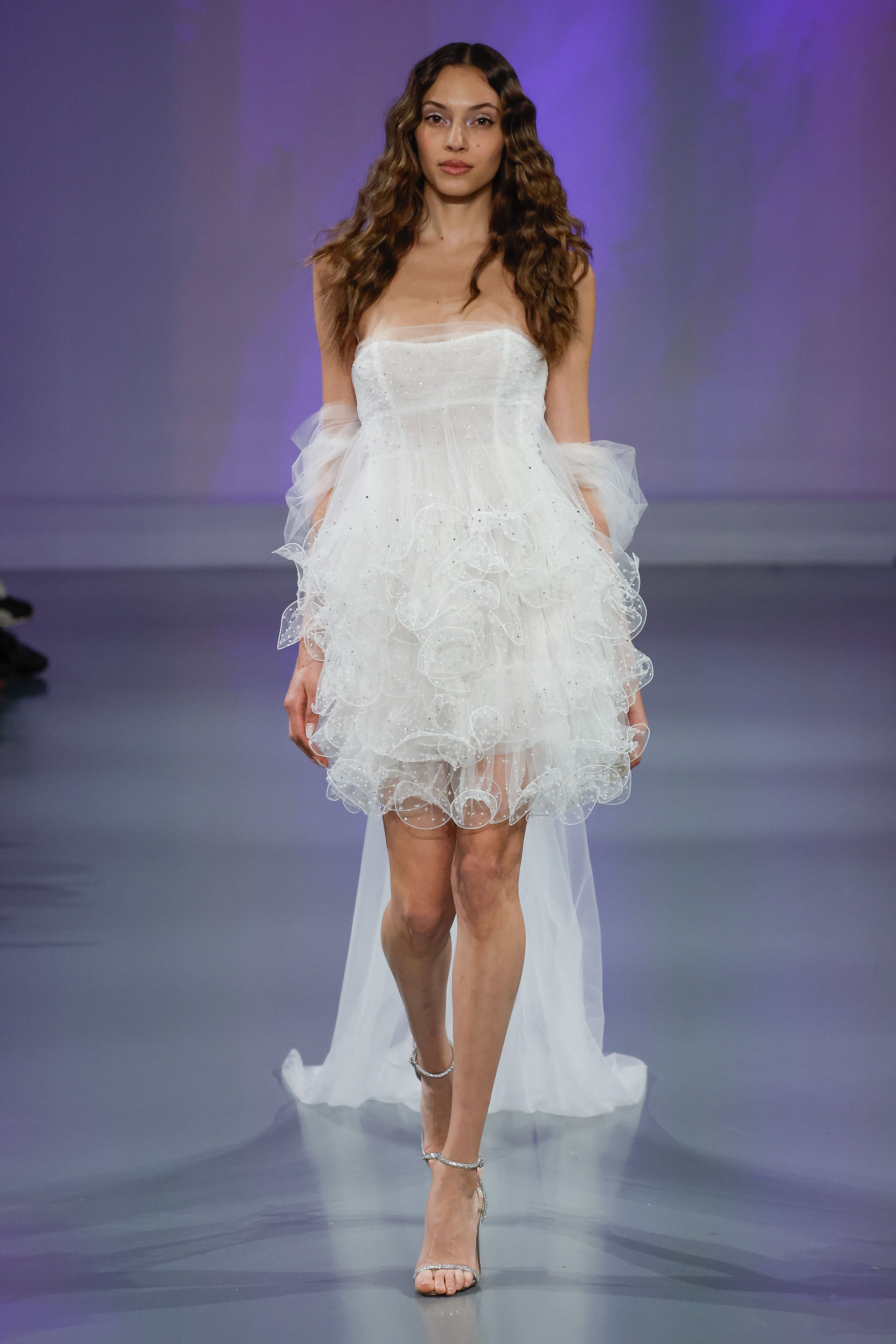 Ines Di Santo Couture Spring/Summer 2025—Lydia - Strapless rouched baby doll mini with ruffled skirt and detachable off-the-shoulder cape with streamers.