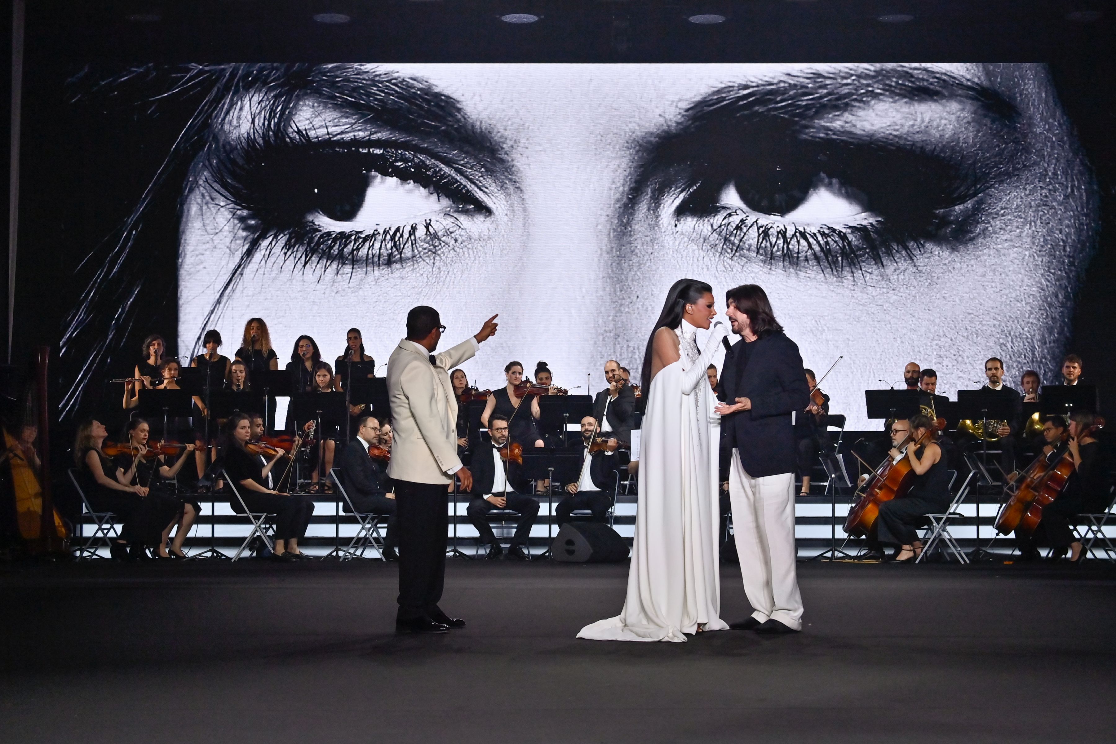 Stephane Rolland with Miss Oumaima Taleb, who wears a long, backless sweater dress in white crêpe embroidered with crystals.