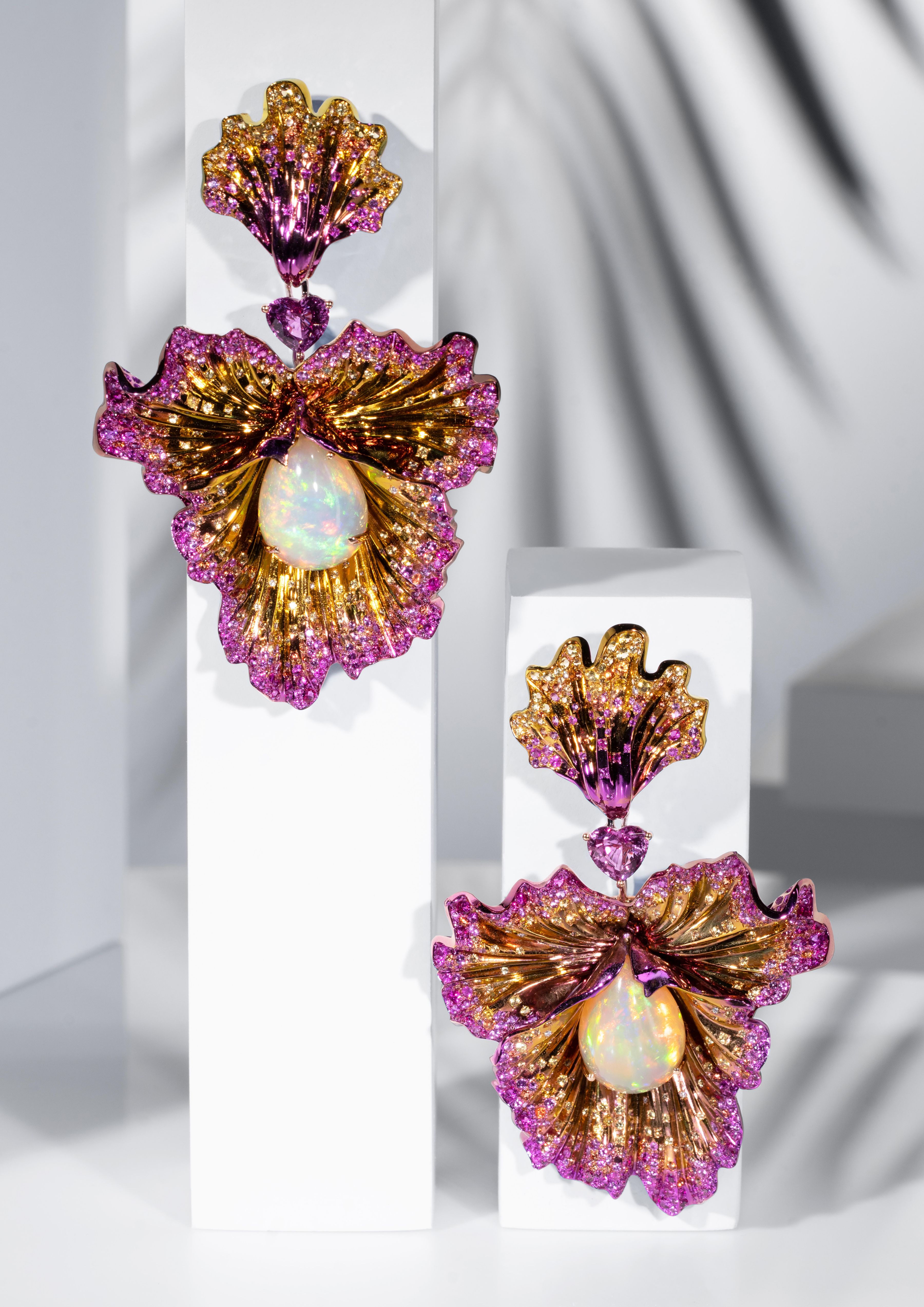 Chopard's Red Carpet Collection 2025, 'Caroline's Universe' - Flower earrings in titanum featuring two white opal cabochons (18.09 cts) and two heart-shaped pink sapphires (3.28 cts), paved with pink (6.84 cts), yellow (3.41 cts) and orange (1.74 ct) brilliant-cut sapphires, as well as ruby and diamond brilliants.