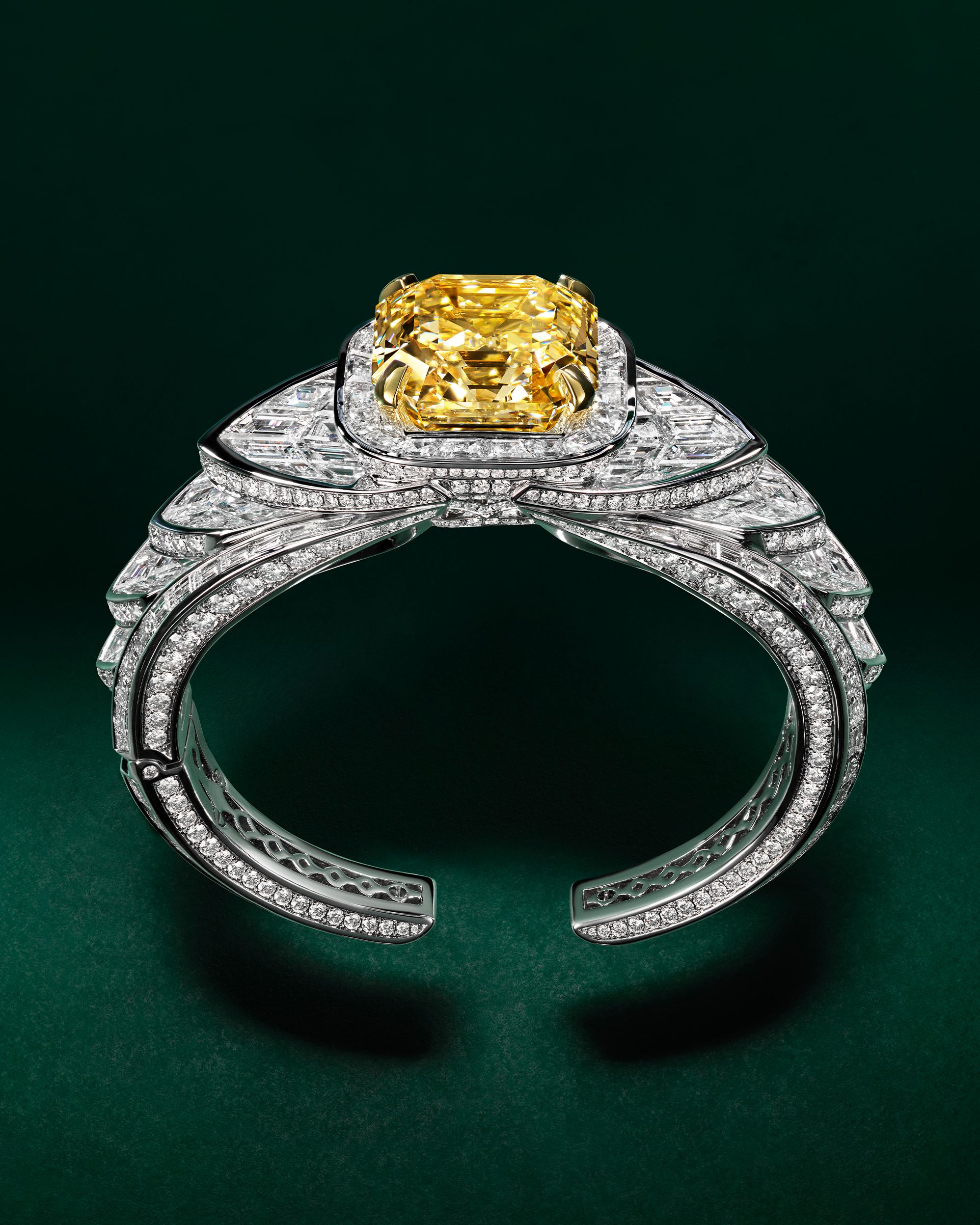 A Graff cuff features graphic lines of white diamonds centered on a 40-carat emerald-cut yellow diamond.
